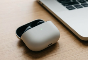 パソコンの横にブルートゥースイヤホンが置いてある画像